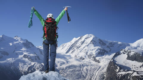 Kaukasischer Wanderer jubelt auf dem Berggipfel, Monte Rosa, Alpen, Italien, lizenzfreies Stockfoto