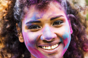 Smiling mixed race woman covered in pigment powder - BLEF14542