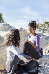 Hikers talking on rocky hilltop - BLEF14575