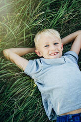 Caucasian boy laying in tall grass - BLEF14623