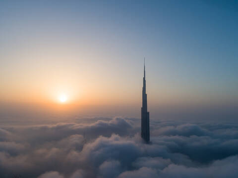 Aerial view of Burj Khalifa Tower in a sea of clouds at sunset in Dubai, United Arab Emirates. stock photo