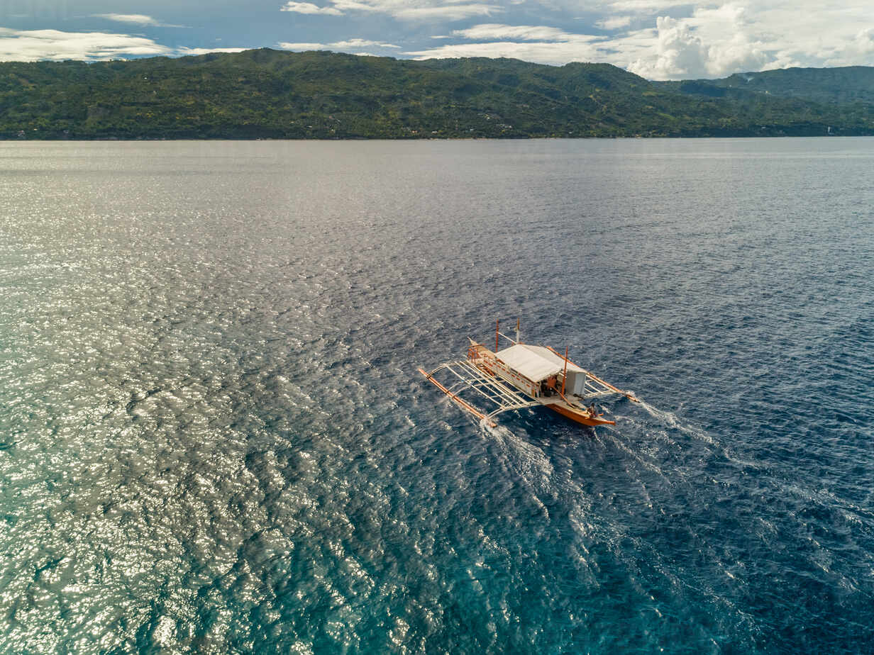 Aerial view of traditional filipino fishing boat by Sumilon island