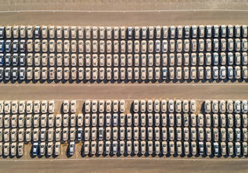 Luftaufnahme einer Gruppe von Autos auf einem Parkplatz in einer Wüstenlandschaft in der Ferne. - AAEF01885