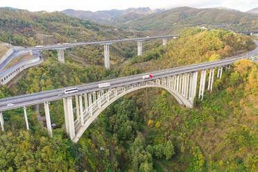 Luftaufnahme einer Bogenbrücke über eine Bergregion, Italien. - AAEF01913