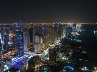 Luftaufnahme von beleuchteten Wolkenkratzern bei Nacht in Dubai, Vereinigte Arabische Emirate. - AAEF01979