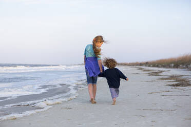 Kaukasischer Bruder und Schwester gehen am Strand spazieren - BLEF14670