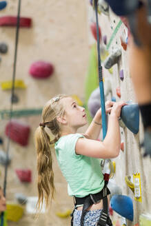 Caucasian girl climbing rock wall indoors - BLEF14681