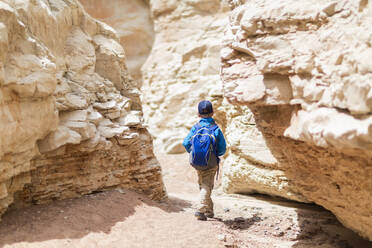 Boy exploring desert rock formations - BLEF14688