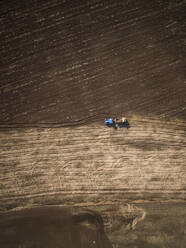 Aerial view of a tractor working on the farmland in Estonia. - AAEF02026