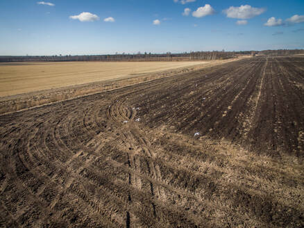 Luftaufnahme von Traktorspuren auf dem Boden eines Ackers in Estland. - AAEF02197