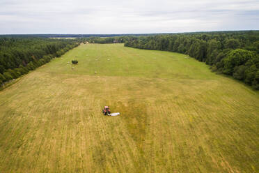 Aerial view of tractor working in farmland in Estonia. - AAEF02207