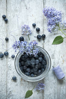 Direkt über der Aufnahme von Blaubeeren in einem Glas auf einem Holztisch - ASF06481