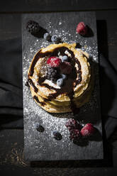 Direkt über der Aufnahme von Pfannkuchen mit Schokoladensauce und Früchten auf dem Tisch - MAEF12924