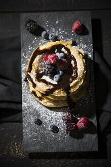 Directly above shot of pancakes with chocolate sauce and fruits on table - MAEF12924