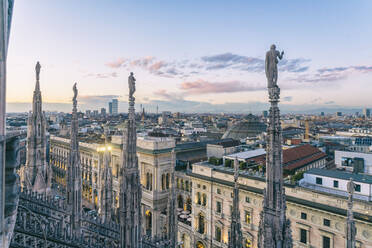 View of the statues on the Cathedral of Milan and the skyline of Milan seen in the background, Milan, Lombardy, Italy, Europe - RHPLF00332