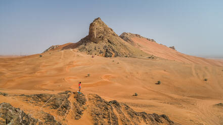 Luftaufnahme eines Mädchens auf einem felsigen Berg bei der Camel Rock Desert Safari in den Vereinigten Arabischen Emiraten - AAEF02239