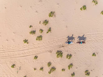 Luftaufnahme von zwei Menschen reiten Pferde in der Wüste, Abu dhabi, VAE. - AAEF02297