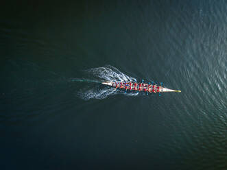 Luftaufnahme eines einzelnen Ruderboots mit Ruderern auf dem Dubai Creek, VAE. - AAEF02332