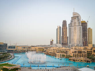 Luftaufnahme von Wolkenkratzern und türkisfarbenem Springbrunnen in der Business Bay, Dubai, VAE. - AAEF02352