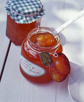 Homemade peach jam in mason jar on table - PPXF00231