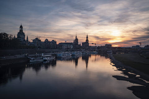 Boote auf der Elbe gegen den Himmel in der Stadt bei Sonnenuntergang, Sachsen, Deutschland, lizenzfreies Stockfoto