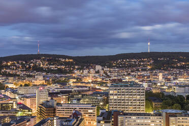 Illuminated buildings and communications tower against cloudy sky at dusk in Stuttgart, Germany - WDF05399