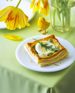 Ziegenkäsetörtchen im Teller mit Blume und Dekoration auf dem Tisch - PPXF00245