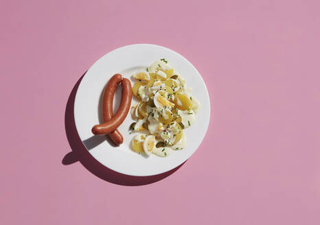 Directly above shot of healthy egg meal by ingredient in plate on pink background - KSWF02059