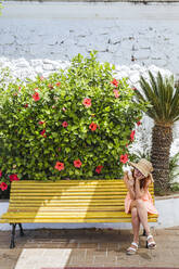 Tourist with icecream cone sitting on a bench having a rest, Frigiliana, Malaga, Spain - LJF00684