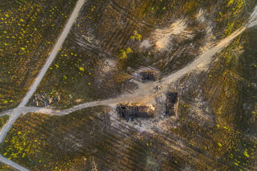 Aerial view road passing by abandoned cabin on growing forest, Estonia. - AAEF02599