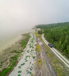 Luftaufnahme einer Straße am Waldrand von Forby auf der Insel Vormsi, Estland. - AAEF02633