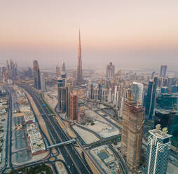 Luftaufnahme des Burj Khalifa Tower umgeben von anderen Wolkenkratzern bei Sonnenuntergang in Dubai, Vereinigte Arabische Emirate. - AAEF02701