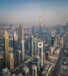 Luftaufnahme des beeindruckenden Burj Khalifa inmitten anderer Wolkenkratzer in Dubai bei Sonnenuntergang, V.A.E. - AAEF02711