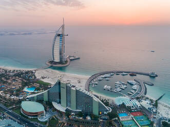 Luftaufnahme des luxuriösen Burj Al Arab Hotels und des Hafens bei Sonnenuntergang an der Küste Dubais, Vereinigte Arabische Emirate. - AAEF02713