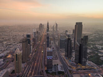 Luftaufnahme der Verkehrsspuren und Wolkenkratzer in Dubai bei Sonnenuntergang, V.A.E. - AAEF02715