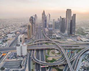 Luftaufnahme von geometrischen Fahrspuren und Wolkenkratzern in Dubai bei Sonnenuntergang, V.A.E. - AAEF02717