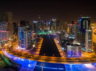 Aerial view of illuminated skyscrapers and canal in Dubai at night, U.A.E. - AAEF02790