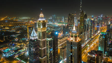 Luftaufnahme von beleuchteten Wolkenkratzern in Dubai bei Nacht, V.A.E. - AAEF02799