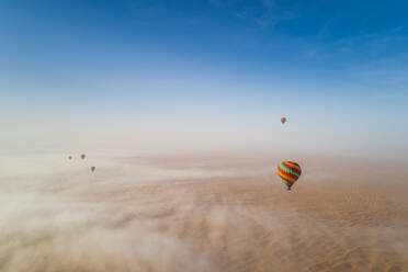 Luftaufnahme eines Heißluftballons, der in den Wolken der Murqquab-Wüste in Dubai, V.A.E., fliegt - AAEF02890