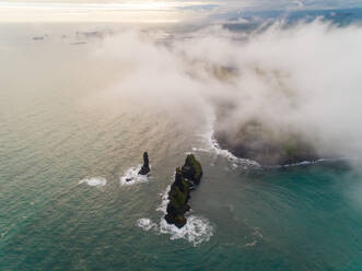 Luftaufnahme über der Wolke von Felsformationen am Ufer, Region Westfjorde, Island. - AAEF02935