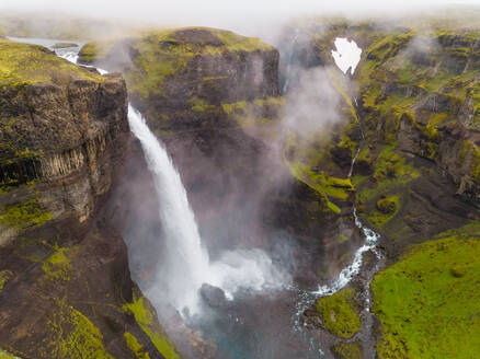 Luftaufnahme des Haifoss-Wasserfalls in der südlichen Region Islands an einem nebligen Tag. - AAEF02949
