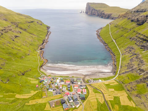Luftaufnahme eines kleinen Dorfes inmitten von Bergen, Färöer-Insel., lizenzfreies Stockfoto