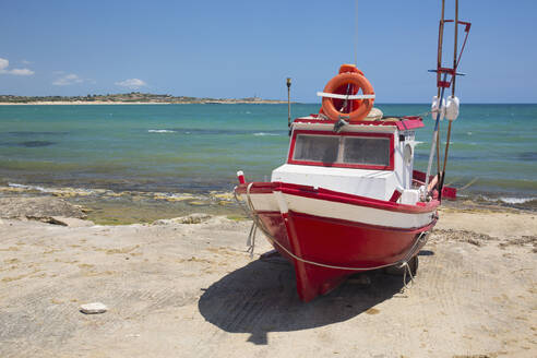 Buntes Fischerboot auf der Helling, dahinter das türkisfarbene Wasser des Mittelmeers, Sampieri, Ragusa, Sizilien, Italien, Europa - RHPLF00589