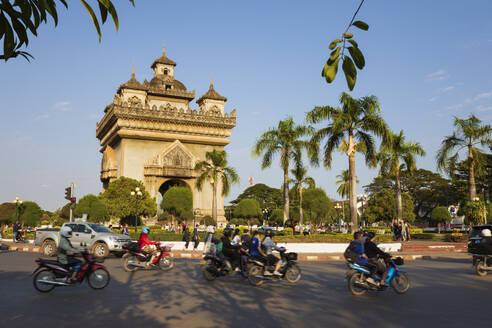 Mopeds fahren am Patuxai-Siegesdenkmal (Vientiane Arc de Triomphe) vorbei, Vientiane, Laos, Indochina, Südostasien, Asien - RHPLF00678
