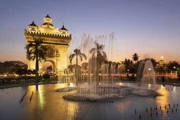 Patuxai Victory Monument (Vientiane Arc de Triomphe) and fountain floodlit at dusk, Vientiane, Laos, Indochina, Southeast Asia, Asia - RHPLF00681