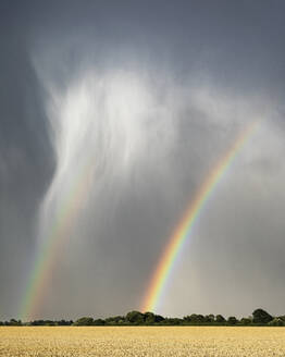 Sommerliche Gewitterwolken und stürmisches Wetter mit einem doppelten Regenbogen bei Lower Dunsforth, North Yorkshire, Yorkshire, England, Vereinigtes Königreich, Europa - RHPLF00714