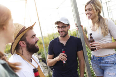 Eine Gruppe von Freunden trinkt Bier und genießt die Zeit im Gewächshaus - JSRF00531