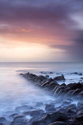 Sunset on a stormy winter's day looking across Kimmeridge Bay from the remains of Clavell's Pier, Kimmeridge, near Swanage, Dorset, England, United Kingdom, Europe - RHPLF00804