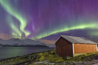 Nordlichter beleuchten die Holzhütte in Svensby, Lyngen Alps, Troms, Lappland, Norwegen, Skandinavien, Europa - RHPLF00990
