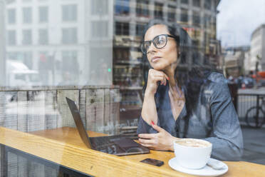 Business woman having a break in a cafe and working with a laptop - WPEF01801